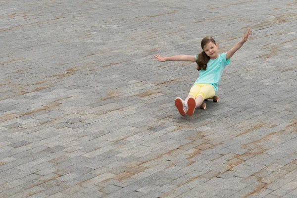 Una Niña Pequeña Sentó Tablero Con Ruedas Gira Sus Manos — Foto de Stock