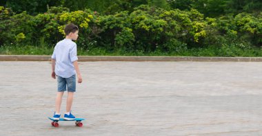 oğlan mavi üzerinde kaykay üzerinde bir taş kare haddeleme, spor, yazıt için bir yer