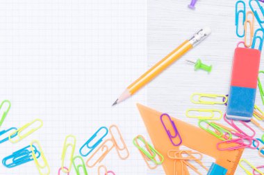 Kağıt ve bir kalem bağlamak için küçük ofis aksesuarları masanın köşesinde yalan