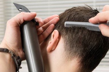 Aracı bir saç kesimi evlat, dikiz çalışan bir stilist elinde