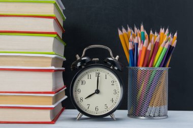 arka plan için bir yığın kitap, zaman ve çok renkli kalemler bir bardak ile çalışma