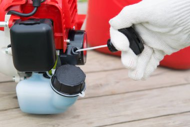 bir koruyucu eldiven El, benzinli motor biçme makinesi başlatmak için kordon çeker