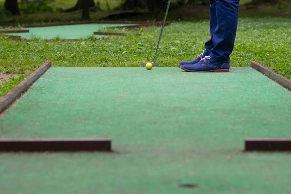 迷你高尔夫游戏 从洞的角度看 用棍子击打一个黄色的球时 — 图库照片