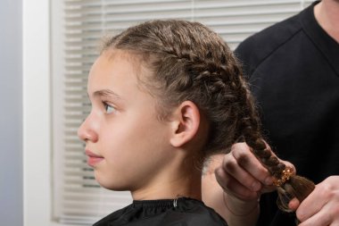 stilist kız saç örgü, yakın çekim yapar.