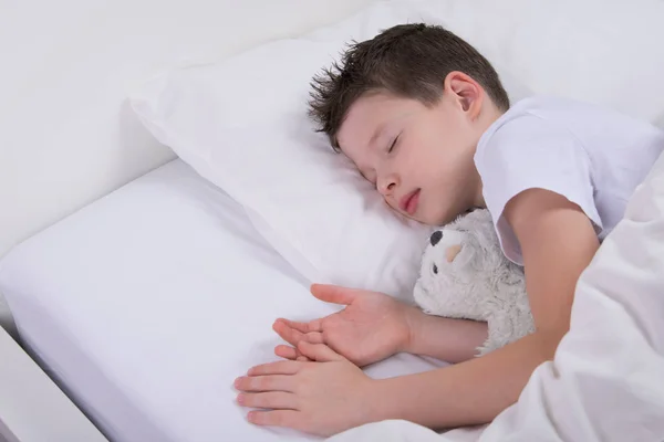 Jego Ulubionej Zabawki Białym Łóżku Śpi Chłopiec — Zdjęcie stockowe