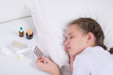 Kız, beyaz yatakta, tıp tablet doktor reçete göre alır.