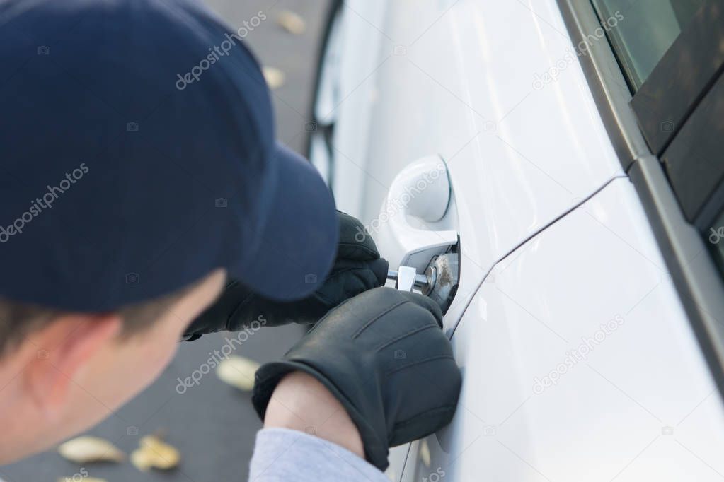 close-up, hacking the lock of access to a car, in violation of private property