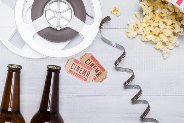 two tickets, beer and popcorn for going to the cinema, background