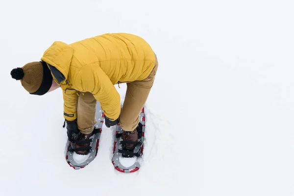 Людина Жовтій Куртці Кладе Снігоступи Білий Сніг — стокове фото