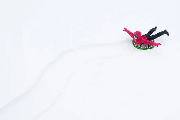 Meisje Een Rode Jas Rijden Een Opblaasbaar Kussen Sneeuw Sporen — Stockfoto