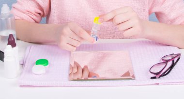 yakın, vizyon geliştirmek için kontak lensler, depolamak için bir kapsayıcı kızın ellerini tutun