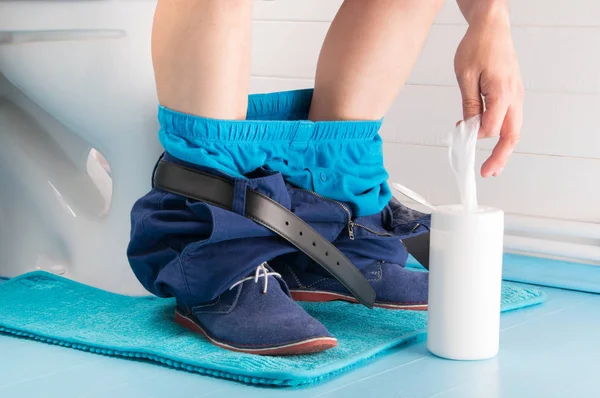 banyo, tuvalet pantolonu ile oturarak ve çeker ıslak mendil davasından bir erkekte