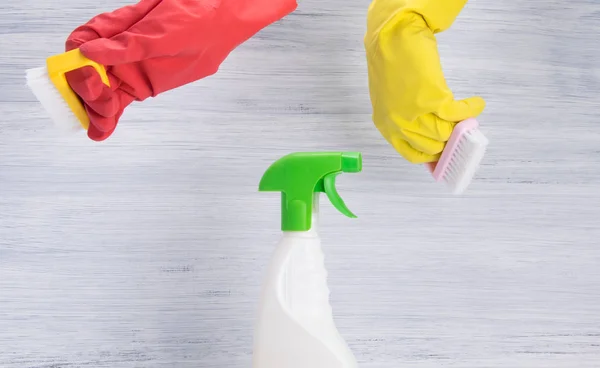 灰色の背景に洗浄剤をスプレー ボトルの横にある赤と黄色 ゴム手袋 ブラシで手 — ストック写真