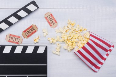 filme bir Klaket ile ahşap bir masa üzerinde patlamış mısır kağıt çanta ve film bilet