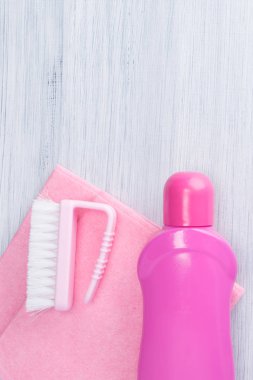 pembe şişe ve temizleme fırçası, yalan bir bez üzerinde gri bir arka plan üzerinde yazıt için bir yer olduğunu