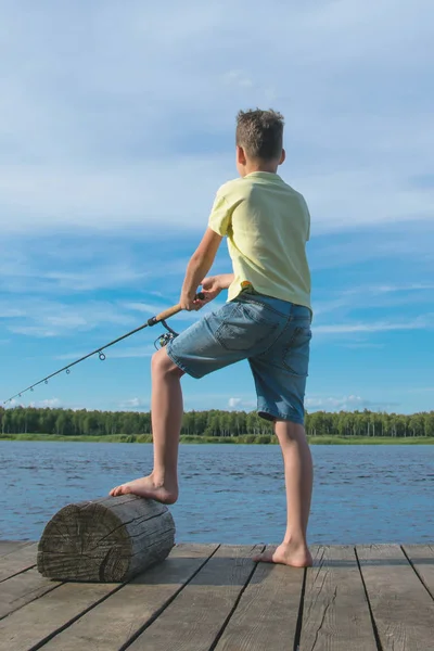 Ragazzo Pesca Sul Molo Contro Cielo Blu Lago Vista Posteriore — Foto Stock