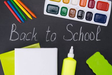 Yakında okula çevrili Kırtasiye, kalem, kalem, kitap tarafından yazılmış yazı tahtası siyah arka plan üzerine