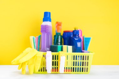 Sepete maddeler ve temizlik ürünleri sarı bir arka plan üzerinde büyük bir set