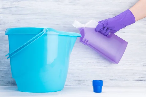 Mano Guante Goma Púrpura Vierte Detergente Cubo Azul — Foto de Stock