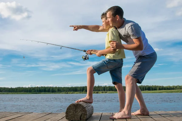Baba Oğlu Mavi Gökyüzüne Karşı Iskelede Balık Tutmayı Öğretir — Stok fotoğraf