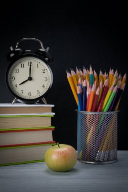 yazı masası üzerinde okul, çalar saat ve kalem ile bir fincan birçok kitaplar