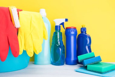 Ev kimyasalları ve lastik eldiven köşedeki sarı bir arka plan üzerinde sağ tarafta bir yazıt için bir yer