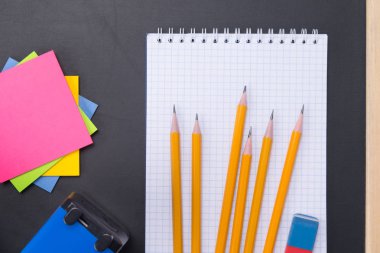 yazmak için öğrenme, çıkartmalar, beyaz notebook, konuların bir kümesiyle kalemler için siyah arka plan