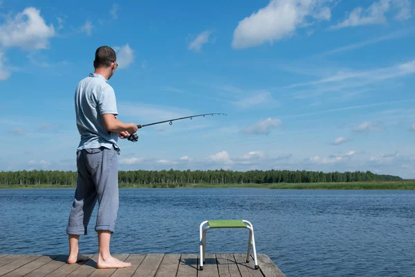 漁師は 美しい青空を背に川で魚をキャッチします — ストック写真