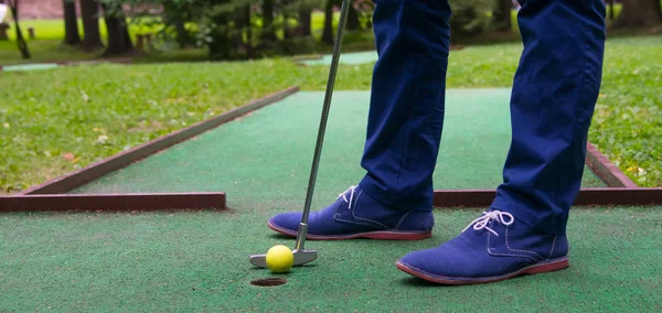 Yeşil mini Golf Sahası, darbe erkekler mavi pantolonlu, önce delik görünümünden yakın çekim