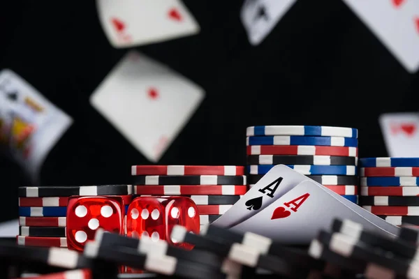 dices and two ace cards surrounded by poker chips background of falling cards