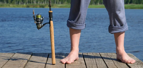 池の桟橋の背景に魚と男性の足をキャッチするために取り組む — ストック写真