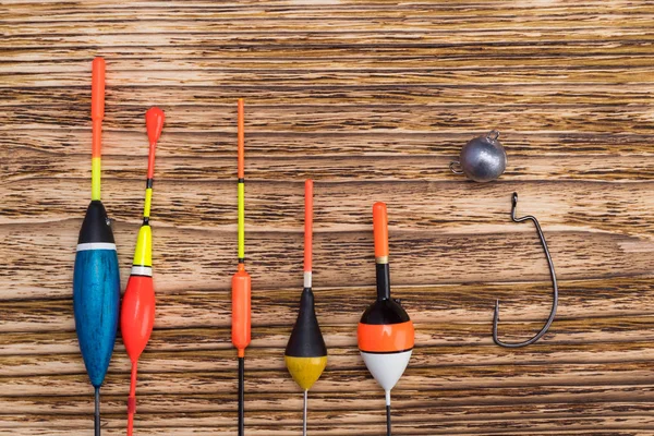 several fishing floats for fishing pole lie on a wooden background