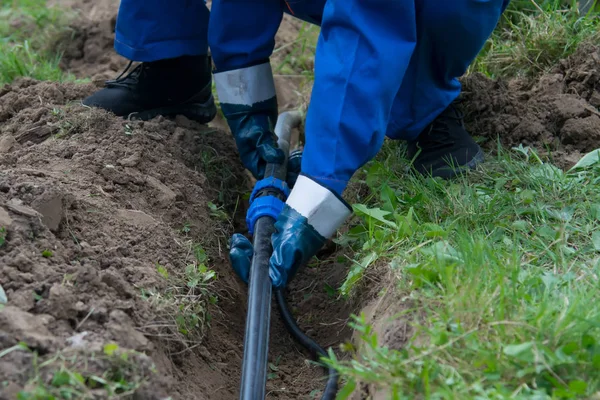 yerdeki açık bir siperde plastik bir boru hattı mavi eldiven, işçinin el koydu