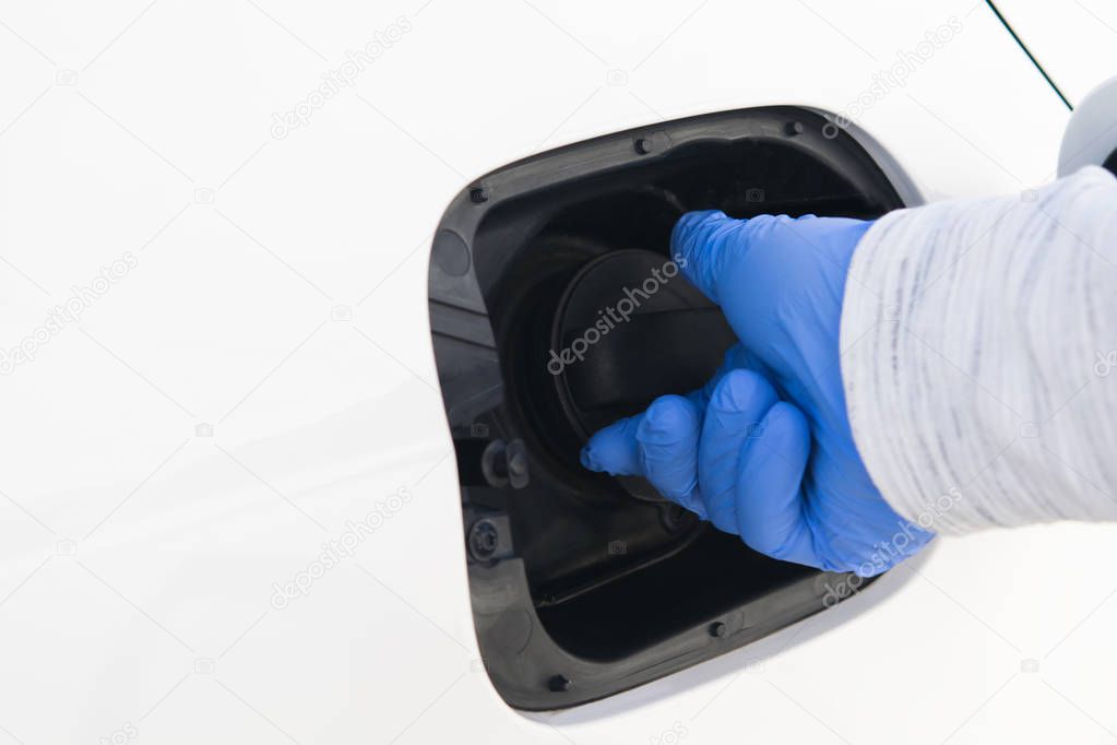 hand in rubber glove closes gas tank in car, closeup