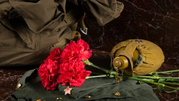 Fundo Monumento Buquê Cravos Vermelhos Mochila Uniforme Militar Balão Água — Fotografia de Stock