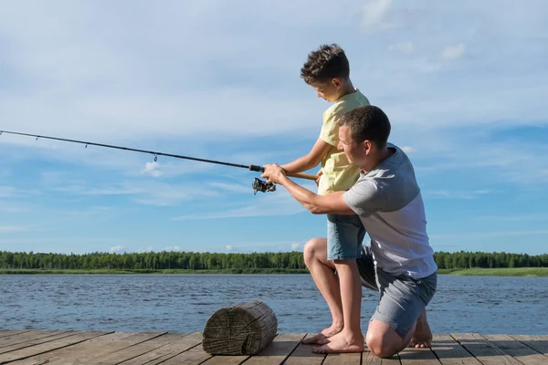 Papá Enseña Hijo Pescar Girar Desde Orilla Del Río —  Fotos de Stock