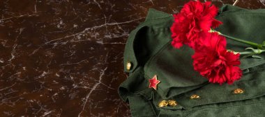 anıtın arka planına karşı, yazıt ölümsüz alay için bir yer ile, askeri üniforma ve şapka üzerinde iki kırmızı karanfil