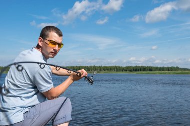 Gözlüklü bir adam nehirde dönen bir adam ile balıkçılık