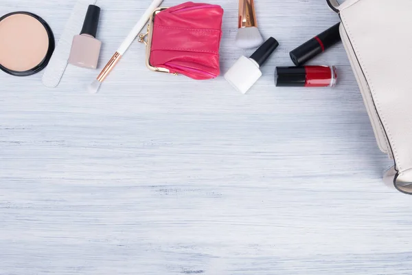 a set of women's accessories, items and cosmetics for applying makeup, which lie next to a white handbag, a place for your inscription