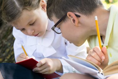 çocuklar dersten sonra iyi havalarda dışarıda oturan sınavlara hazırlanırlar