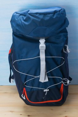 mavi ve ahşap arka plan üzerinde, gezgin için mavi bir sırt çantası yakın çekim