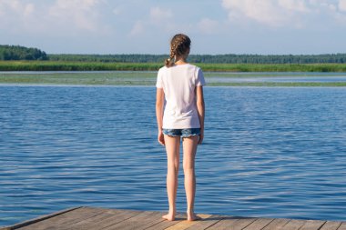 kız güneşli bir günde yoga yapmak için nehre geldi, arka görüş