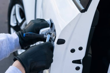 hırsız beyaz arabanın kapısının kilidini kırdı ve yakın çekim, açtı