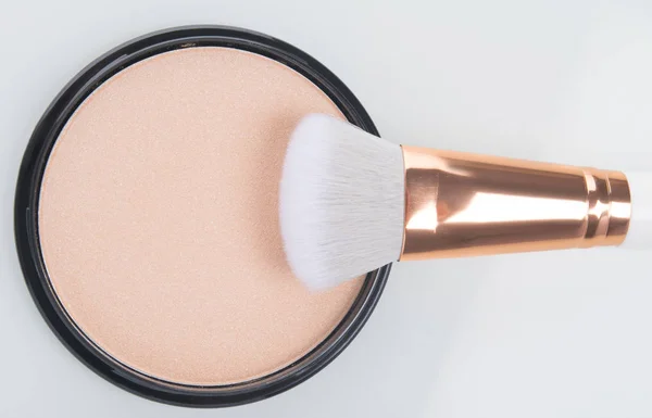 close-up of face powder to smooth the makeup brush on white background