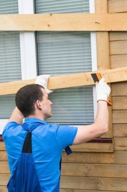 bir adam bir pencerede tahtalar içine çivi tekmeler, doğal afetler onları kapatır