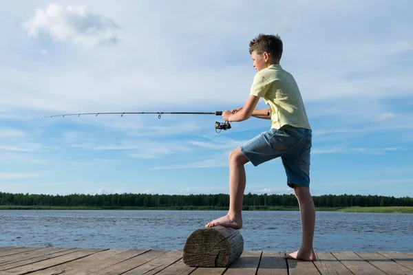Menino Pega Peixe Com Uma Vara Pesca Lago Contra Fundo — Fotografia de Stock
