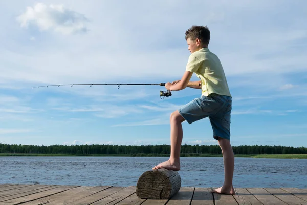 Ragazzo Cattura Pesce Con Una Canna Pesca Lago Sullo Sfondo — Foto Stock