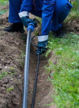 mavi eldiven ustası, su üzerinde, eve zemin de siper siyah bir boru döşeme