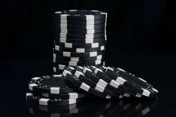反射面に黒いカジノチップのスタック — ストック写真