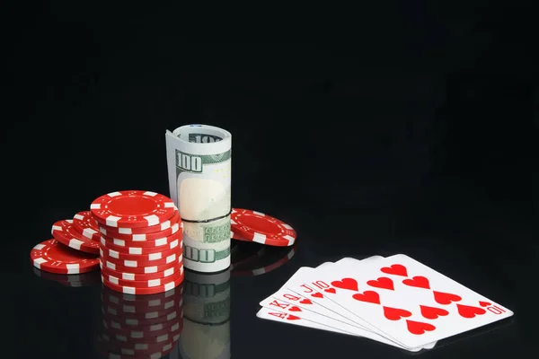 ポーカー ストローとカードのセットに包まれた赤いチップのピラミッド まっすぐ 反射のある黒い背景に — ストック写真